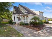 Charming exterior featuring a well-maintained lawn and colorful flowering plants on the porch at 1422 Baldwin Ct. # 1422, Little River, SC 29566