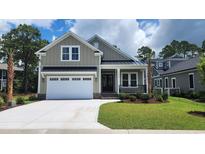 Charming two-story home featuring a manicured lawn, inviting porch, and convenient two-car garage at 1424 Hydrangea Dr., Myrtle Beach, SC 29579