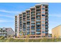 Multi-story condo building featuring private balconies, offering stunning views of the surrounding landscape and blue sky at 1501 Ocean Blvd. S # 103, North Myrtle Beach, SC 29582