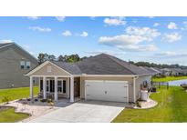 Charming single-story home with a two-car garage and manicured landscaping, near a water feature at 1664 White Starfish Ct., Calabash, NC 28467