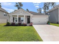 Charming home featuring a well-manicured lawn, inviting front porch, and an attached two-car garage at 179 Empyrean Circle, Myrtle Beach, SC 29588