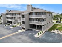 Three-story condo building showcases covered parking, multiple decks, neutral color palette, and well-maintained landscaping at 1801 N Ocean Blvd. # Q-2, North Myrtle Beach, SC 29582