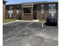 Brick building exterior with parking spaces in front on a sunny day at 2005 Greens Blvd. # F-205, Myrtle Beach, SC 29577