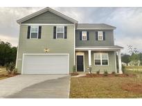 Two-story home with green siding, black shutters, white garage door, and manicured lawn at 292 Clear Lake Dr., Conway, SC 29526