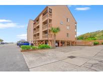 Beautiful exterior view of elevated condo building with private balconies and convenient covered parking at 3211 S Ocean Blvd. # 204, Myrtle Beach, SC 29577