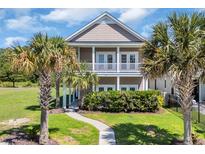 Charming two-story home with double porches and lush landscaping featuring mature palm trees at 338 St. Julian Ln., Myrtle Beach, SC 29579
