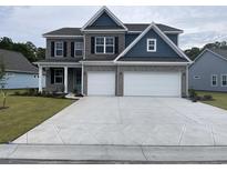 Attractive two-story home boasting a gray brick facade, a two-car garage, and a beautifully patterned driveway at 3391 Moss Bridge Ln., Myrtle Beach, SC 29579