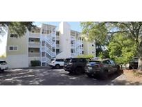 Condo exterior showcasing white staircases, yellow paint, and parking spaces at 3401 Dunes St. # A3, North Myrtle Beach, SC 29582
