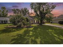 Charming home with lush front yard, mature trees, well-maintained lawn, and inviting landscaping at 3910 Stillwood Dr., Myrtle Beach, SC 29588