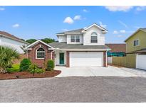 Charming two-story home featuring a red brick facade, a two-car garage, and a well-manicured lawn at 4002 Acorn Way, North Myrtle Beach, SC 29582