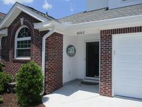 Charming brick front entrance with white trim, manicured landscaping, and a bright, welcoming entryway at 4002 Acorn Way, North Myrtle Beach, SC 29582