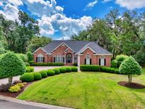 Beautiful brick home with manicured landscaping and a circular driveway at 423 Chapman Loop, Pawleys Island, SC 29585