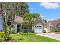 Charming one-story home with well-manicured lawn, attached garage, and a welcoming front porch at 4406 Barcelona Ln., Little River, SC 29566