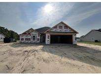 Under construction home showcasing the layout, garage, and placement on a sandy lot at 475 Highway 348, Loris, SC 29569