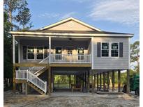 Two-story beach house with elevated structure, gray siding, and covered porch at 4823 Riverside Dr., North Myrtle Beach, SC 29582