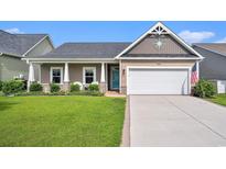 Charming single-story home with a well-manicured lawn, inviting front porch, and attached two-car garage at 505 Joy Way Ct., Longs, SC 29568