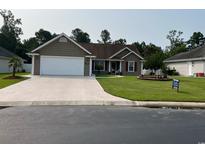 Charming single-story home with a well-manicured lawn and a white two car garage at 550 Bridgeport Dr., Myrtle Beach, SC 29577