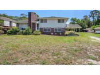 Charming two-story home with a brick chimney and covered patio, surrounded by a lush green yard at 5612 N Kings Hwy., Myrtle Beach, SC 29577