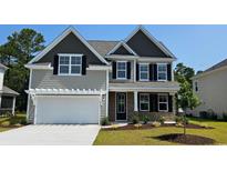 Charming two-story home with stone accents, neutral siding, a two-car garage, and manicured landscaping at 720 Rupert Dr, Conway, SC 29526