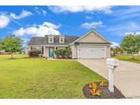 Charming home featuring a well-manicured lawn, two-car garage, and a classic design with dormer windows at 732 American Beech St., Loris, SC 29569