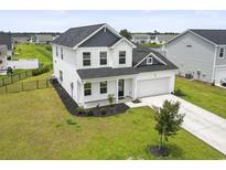 Beautiful two-story home boasting black roof, white siding, manicured lawn, and an attached two-car garage at 863 Agostino Dr., Myrtle Beach, SC 29579