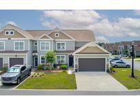 Charming townhome with a well-manicured lawn, neutral siding, and an attached garage at 115 Machrie Loop # D, Myrtle Beach, SC 29588