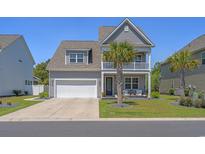 Charming two-story home features a two-car garage, upper balcony, and mature landscaping with palm trees at 1168 Baker Creek Loop, Myrtle Beach, SC 29579