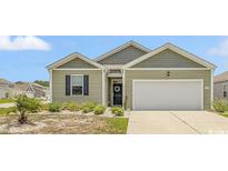 Charming single-story home features a well-manicured lawn, neutral siding, and an attached two-car garage at 1170 Maxwell Dr., Little River, SC 29566