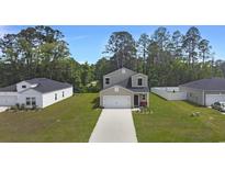 Charming two-story home featuring a well-manicured lawn and a concrete driveway leading to an attached garage at 120 Carolina Lakes Blvd., Myrtle Beach, SC 29588