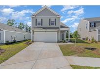 Charming two-story home with a gray exterior, well-manicured lawn, and a two car driveway at 1403 Nokota Dr., Conway, SC 29526