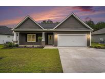 Charming single-story home with well-maintained lawn, gray siding, and a two-car garage at sunset at 1476 Burriss Rd., Conway, SC 29526