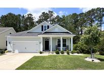 Charming one-story home with a manicured lawn, white garage door, and inviting front porch with rocking chairs at 200 Ponte Vedra Dr., Murrells Inlet, SC 29576