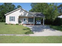 Charming single-story home featuring a well-manicured lawn, carport, and inviting front entrance at 304 S Magnolia Ave., Andrews, SC 29510