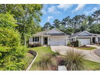 Charming single-story home with a well-manicured lawn, complemented by mature trees and a paved driveway at 340 Scottsdale Ct., Murrells Inlet, SC 29576