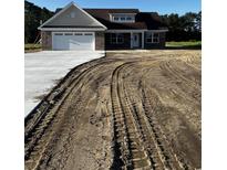 New construction home featuring brick facade, attached garage, and a newly poured concrete driveway at 3444 Asbury Rd., Aynor, SC 29511