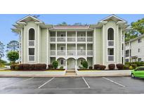 Inviting condo with pale green siding, white trim, multiple balconies, and meticulous landscaping at 4648 Greenbriar Dr. # D2, Little River, SC 29566