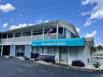 Two-story building exterior featuring a balcony, blue awning, and an American flag at 5409 North Ocean Blvd. # 106/7108, North Myrtle Beach, SC 29582