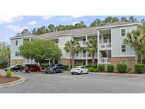 Beautiful condo building featuring well-maintained landscaping, white railings, and ample parking spaces at 6253 Catalina Dr. # 733, North Myrtle Beach, SC 29582