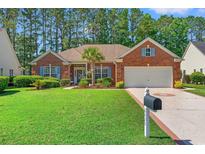 Charming brick home featuring manicured lawn, a two-car garage, and inviting curb appeal at 6420 Longwood Dr., Murrells Inlet, SC 29576