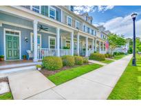 Charming row of blue townhomes featuring inviting front porches and manicured landscaping along the sidewalk at 750 Shine Ave. # 750, Myrtle Beach, SC 29577