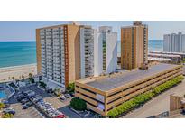 View of the Sands Ocean Club exterior showcasing oceanfront access, parking, and nearby beach at 9550 Shore Dr. # 529, Myrtle Beach, SC 29572