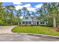 Charming two-story home showcases a manicured lawn, complemented by mature trees and a curved driveway at 103 Pigeon Forge Ct., Murrells Inlet, SC 29576