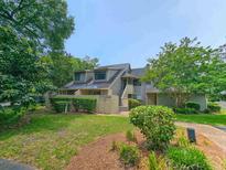 Inviting exterior view of townhouse with lush landscaping, greenery, and a quaint entrance at 108 Westhill Circle # 7-E, Myrtle Beach, SC 29572