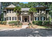 Charming home featuring brick entrance, lush landscaping, and inviting front porch at 159-1 Weehawka Way # 159-1, Pawleys Island, SC 29585