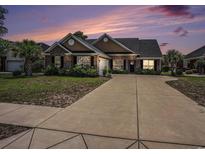 Charming brick home with a well-manicured lawn and long driveway leading to the attached garage at 2004 Potomac Ct., Myrtle Beach, SC 29579