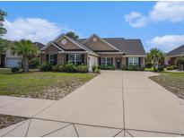 Charming single-story brick home with landscaped yard, palm trees, and a wide driveway on a sunny day at 2004 Potomac Ct., Myrtle Beach, SC 29579