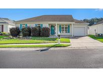 Charming single-story home with blue shutters, well-manicured landscaping, and an attached garage at 264 La Patos Dr., Myrtle Beach, SC 29588