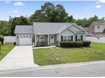 Charming single-story home with well-maintained landscaping, a driveway and an American flag at 3468 Trailside Dr., Little River, SC 29566
