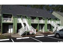 Exterior view of two-story condominium with green siding, white railings, and stairs to second-floor entrances at 411 Cambridge Circle # D4, Murrells Inlet, SC 29576