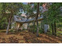 Charming two-story home nestled among trees with a metal roof and inviting front porch at 4131 Gunter Lake Rd., Galivants Ferry, SC 29544